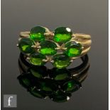 A 9ct hallmarked tsavorite garnet cluster ring comprising seven oval claw set stones, weight 3.5g,