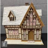 A dolls house modelled as a church, four rooms, two hinged doors to front and two hinged roof