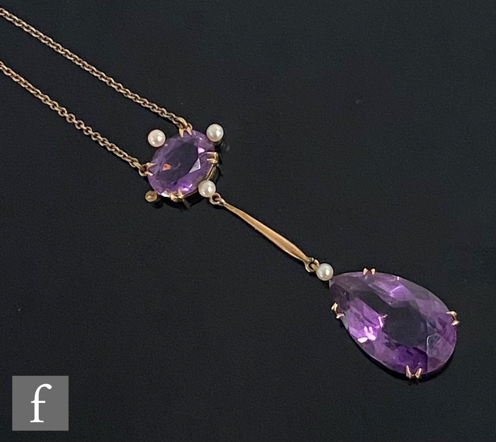 An early 20th Century 9ct two stone amethyst and seed pearl pendant, pear shaped amethyst drop below