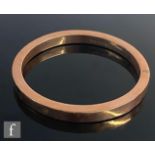 A 9ct hallmarked rose gold stiff upper arm bangle of plain form, weight 16.4g, Birmingham 1921, S/D.