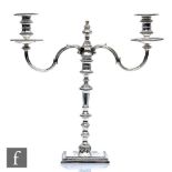 A hallmarked silver twin light cast candelabra, square base with gadroon detail to border below