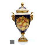 A Coalport twin handled vase and cover decorated with a hand painted cartouche scene of apples and