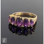 An Edwardian style 9ct hallmarked graduated five stone amethyst ring, claw set stones to chamfered