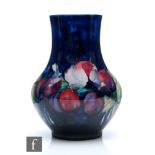 A Moorcroft vase of footed globe and shaft form decorated in the Wisteria pattern, impressed mark