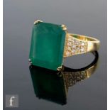 A 18ct hallmarked emerald and diamond ring, central emerald cut claw set emerald, weight