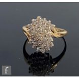 A modern 14ct diamond cluster ring, individually claw set brilliant cut stones to a slight twist,