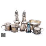 Eight assorted hallmarked silver condiments to include two pairs of peppers, two drum mustard pots