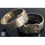 Two hallmarked silver hinged buckle bangles each with foliate scroll engraved decoration, total