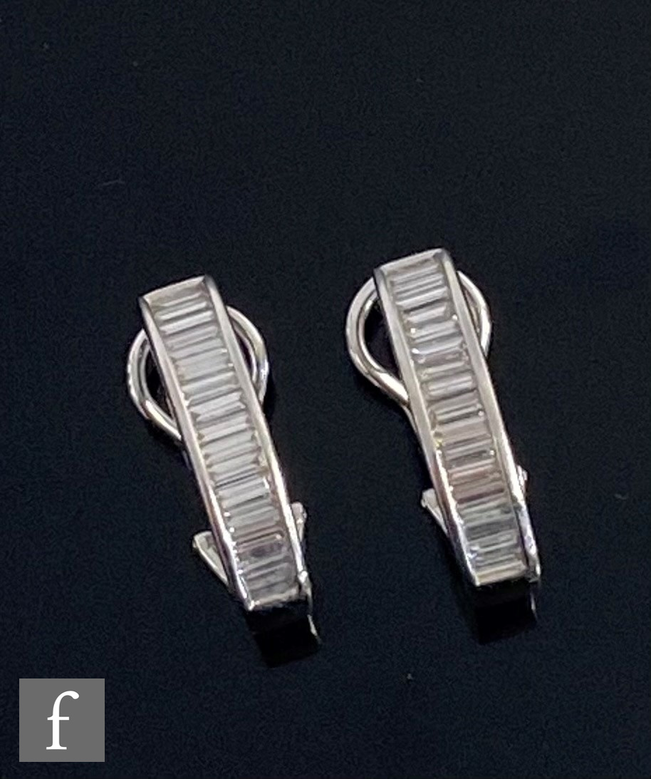 A pair of 18ct hallmarked white gold diamond stud half hoop earrings, each comprising eighteen