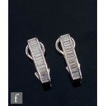 A pair of 18ct hallmarked white gold diamond stud half hoop earrings, each comprising eighteen