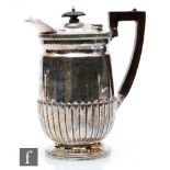 A hallmarked silver hot water pot with part fluted decoration terminating in angular wooden