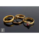 Four assorted 22ct rings to include a ruby and diamond two stone, two wedding rings and a seed pearl