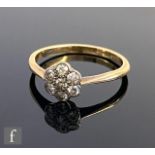 An early 20th Century seven stone diamond daisy cluster ring, old cut stones to knife edged