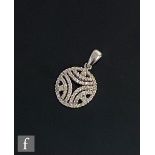 A 9ct hallmarked white gold diamond set circular pendant with pierced decoration, weight 3.1g,