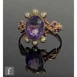 A 9ct rose gold amethyst and seed pearl ring, central oval amethyst flanked above and below by three