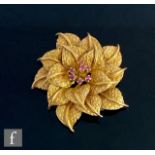 A mid 20th Century 18ct brooch modelled as a flower head with a cluster of seven claw set rubies