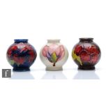 Three miniature Moorcroft Pottery vases of globular form comprising two decorated in the Hibiscus
