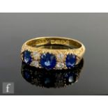 An 18ct hallmarked sapphire and diamond seven stone boat shaped ring, three sapphires spaced by
