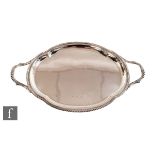 A hallmarked silver twin handled shaped oval tray of plain form terminating in gadroon decorated