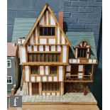 A large dolls house modelled as a Tudor house, three storeys with attic, with external staircase and