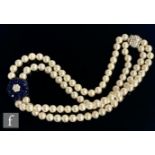 A double row choker of uniform cultured pearls with central seven stone diamond cluster within a