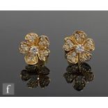 A pair of 18ct diamond stud earrings modelled as a flower head, with central diamond within a