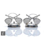 A pair of hallmarked silver menu holders each modelled as a pair of cross tennis rackets with a