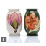 Two miniature Moorcroft Pottery barrel vases, the first decorated in the Hibiscus pattern, the