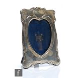 An early 20th Century hallmarked silver easel photograph frame with heart shaped aperture below
