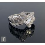 An 18ct white gold diamond ring, two rows of fourteen tapering baguette channel set stones flanked