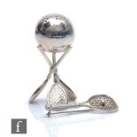 A silver plated pepper pot modelled as three tennis rackets and a ball, height 6.5cm, with a