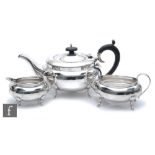 A hallmarked silver three piece boat shaped tea set of plain form, total weight 34oz, terminating in