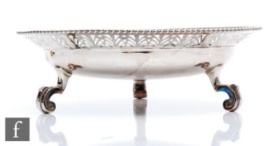 A hallmarked silver bowl raised on three scroll feet and terminating in stylised fan pierced border,