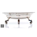 A hallmarked silver bowl raised on three scroll feet and terminating in stylised fan pierced border,