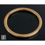 An early 20th Century 15ct hallmarked hollow stiff bangle of plain cylindrical form, weight 12g,