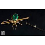 A 9ct bar brooch modelled as a spider with green stone and pearl body, weight 9g, length 6.5cm, with