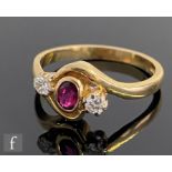 An 18ct hallmarked ruby and diamond three stone ring, central ruby flanked by a diamond either