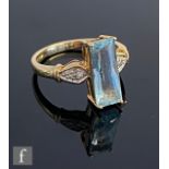 A 9ct hallmarked blue topaz and diamond ring, central emerald cut topaz flanked by diamond set