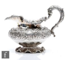 A Victorian hallmarked silver pedestal cream jug with crimped decorative foot below heavily