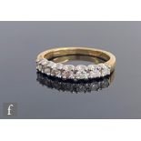 An 18ct diamond half eternity ring, seven claw set brilliant cut diamonds to plain shoulders, weight