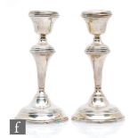 A pair of hallmarked silver candlesticks, each with reeded decoration to circular bases, knops and