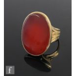 A 9ct hallmarked single stone carnelian ring, collar set stone to split shoulders and a ribbed