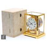 A Jaeger-Lecoultre Atmos clock, circular white dial in brass glazed case on bracket plinth base,