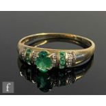 A 9ct hallmarked emerald and diamond ring, five emeralds spaced by pave set diamonds, weight 1.7g,