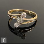 An early 20th Century 18ct diamond three stone ring, millgrain set stones to a slight twist,
