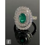 A modern 18ct hallmarked emerald and diamond cluster ring, central oval, collar set emerald,
