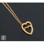 An 18ct hallmarked open double heart pendant signed Cartier and suspended from 9ct trace chain,