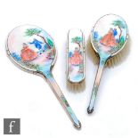 A hallmarked silver and enamelled three piece brush set decorated with a courting couple in a