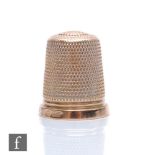 An early 20th Century 9ct thimble of typical form, weight 4.8g, height 2cm, stamped 9ct, Charles