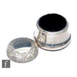 A hallmarked silver circular trinket box of plain body below pull off cover with a floral